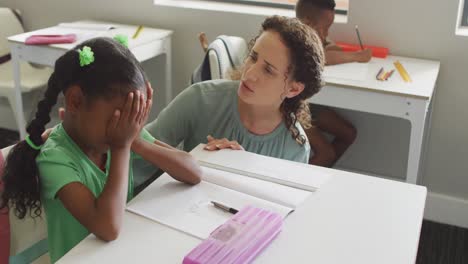 video of caucasian female teacher supporting sad african american girl during lessons