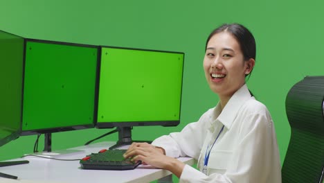 woman at a computer with multiple monitors