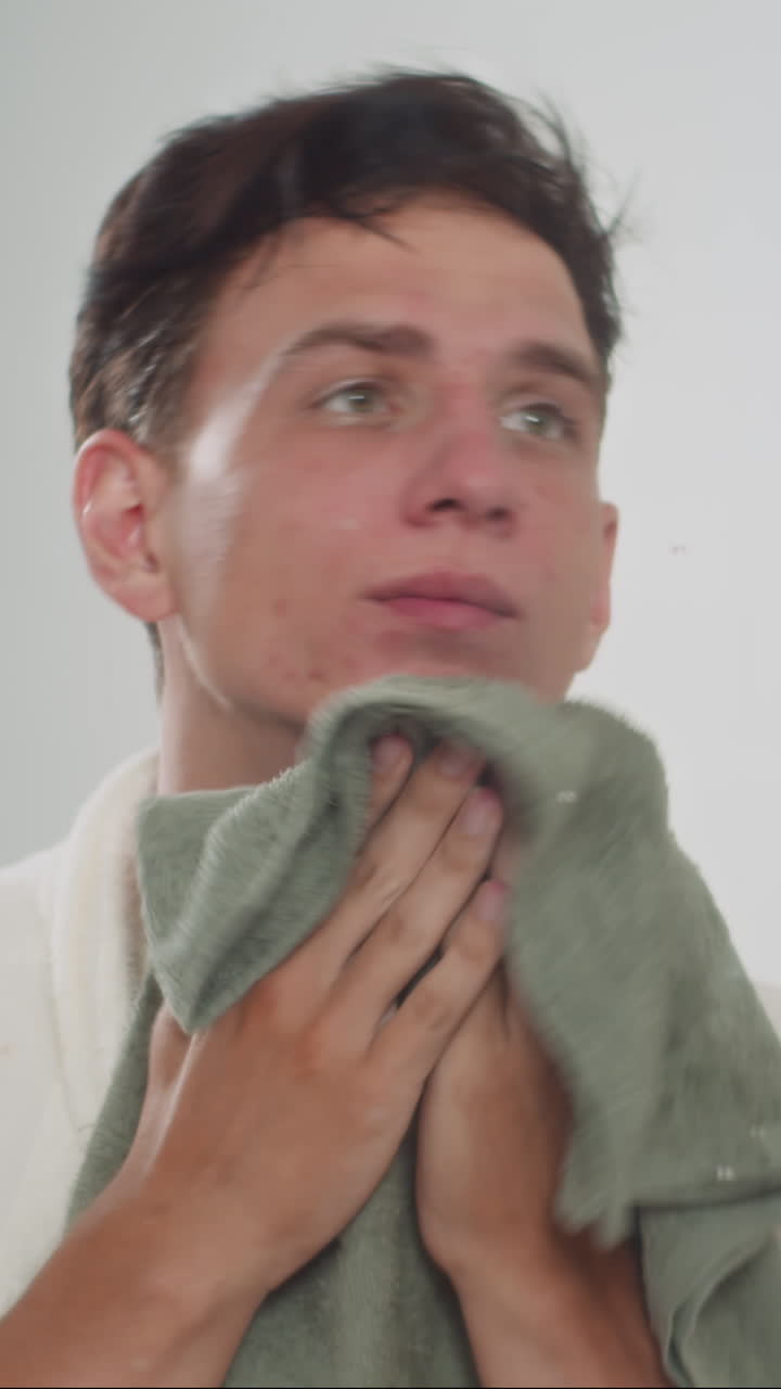 Man Wiping Face with Rowel after Beauty Procedures at Home