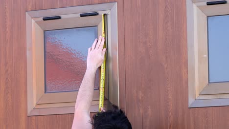 Usando-Cinta-Métrica-En-Las-Ventanas-De-Un-Edificio