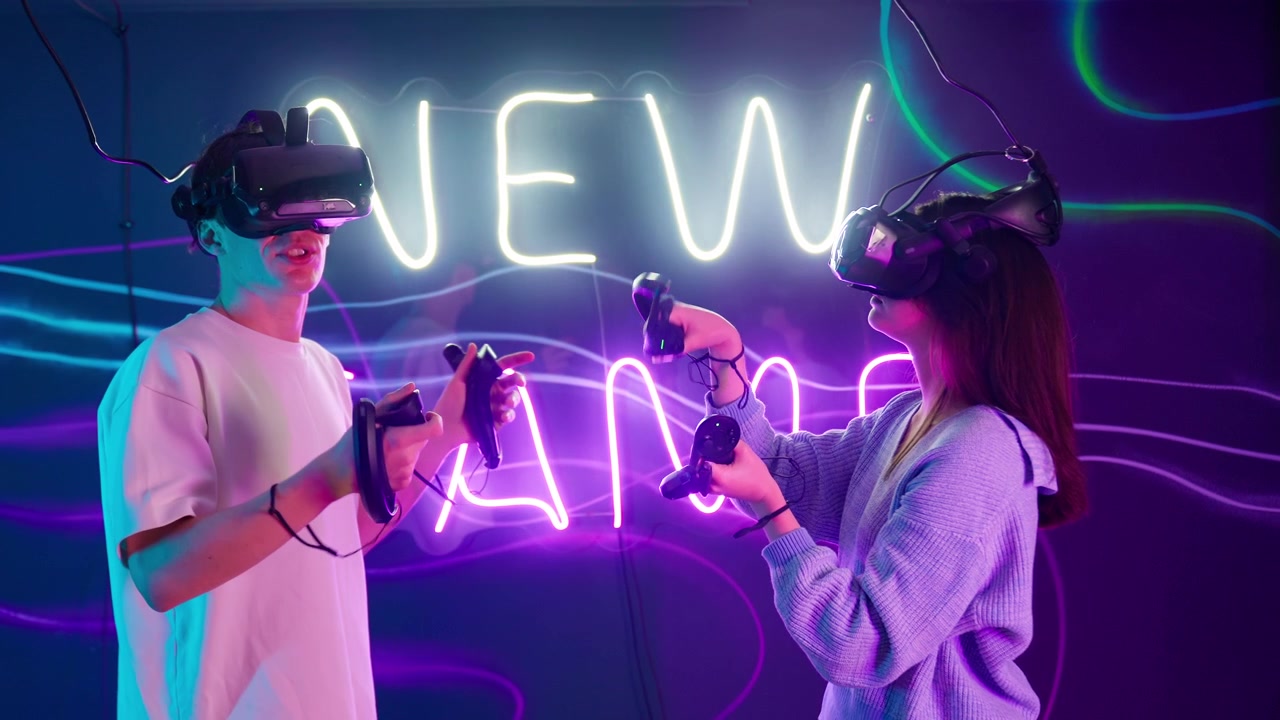 Nuori pariskunta pelaamassa virtuaalitodellisuuspeliä neonvaloin valaistussa huoneessa