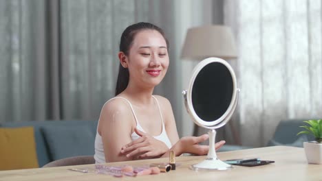 mujer aplicando maquillaje frente a un espejo