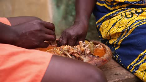 two african women eating fish soup with their hands