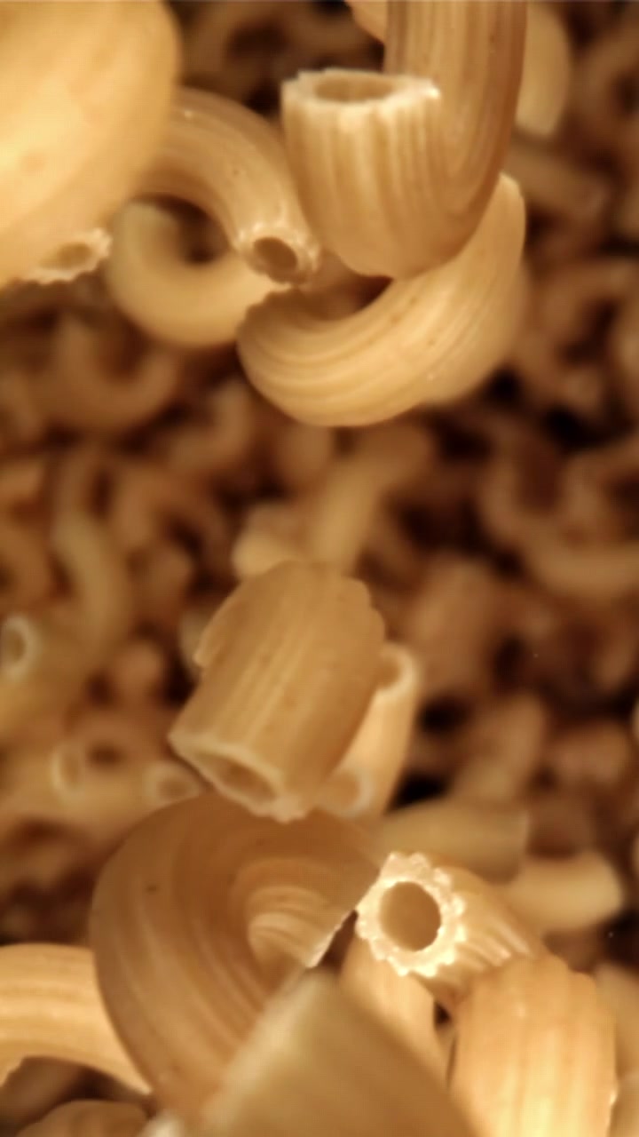 Pasta maccheroni cruda che cade al rallentatore