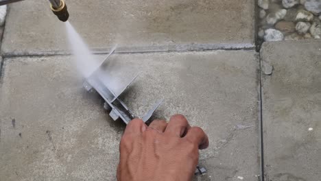 cleaning a metal part with a pressure washer