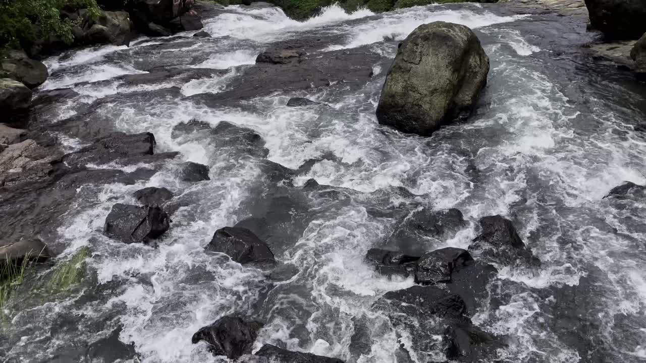A stunning waterfall cascades down rugged cliffs in Bhandardara, Maharashtra, India, surrounded by lush greenery. The monsoon aura enhances the misty charm 4K