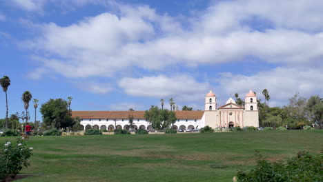 Reveal-shot-of-the-Santa-Barbara-Mission-building-from-behind-flowers-in-the-rose-garden-in-California