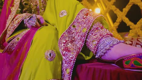 an asian bride photo shoot at the event of mehndi, a close up of her foot wear and dress