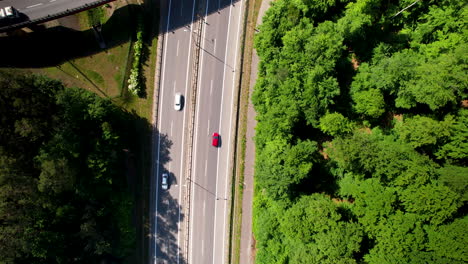 Vista-Aérea-De-4k-De-Autos-En-El-Paso-Elevado-De-La-Autopista-Con-Bosque-Verde-Al-Lado