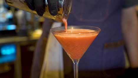 pouring alcoholic orange drink in a bar