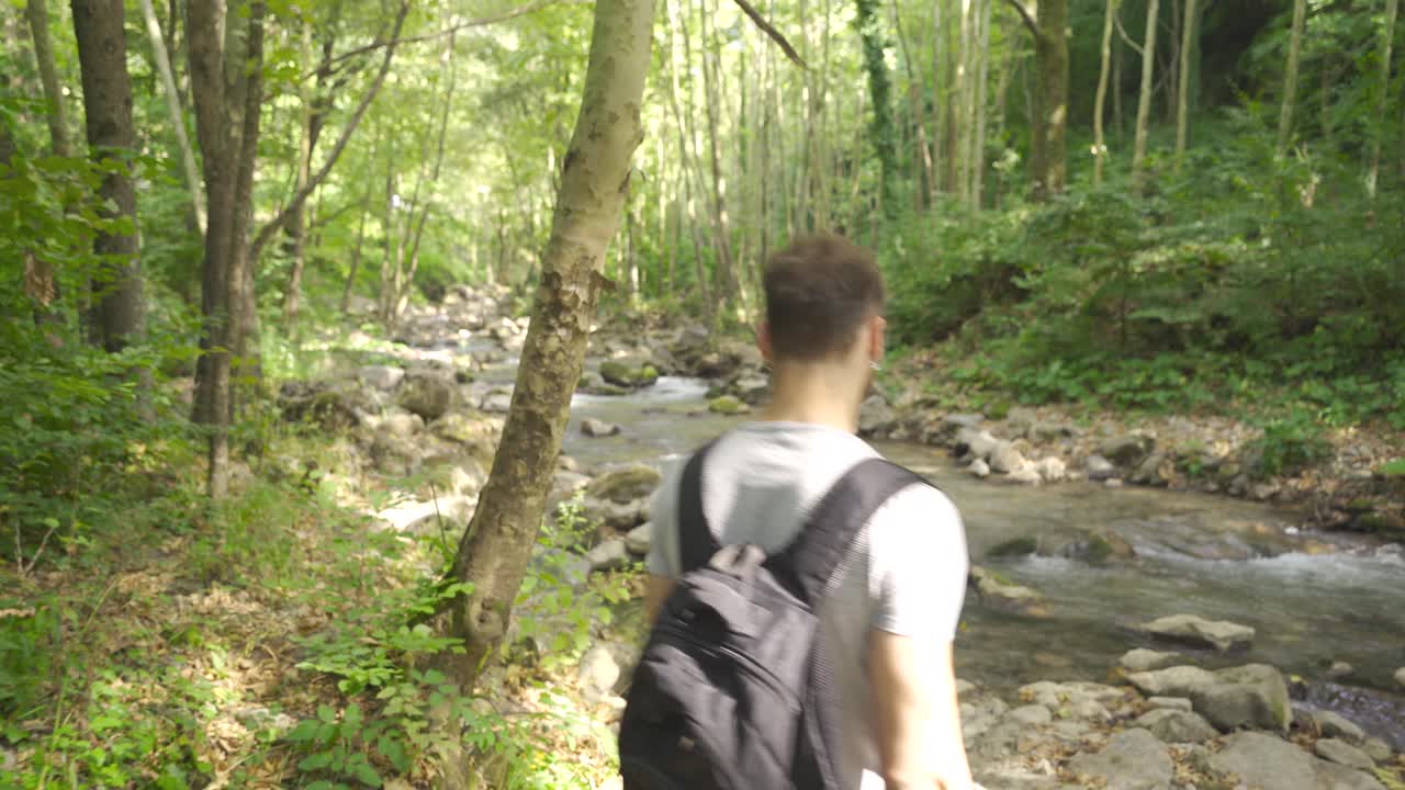 젊은이가 하천에서 물의 흐름을 지켜보고 있습니다.