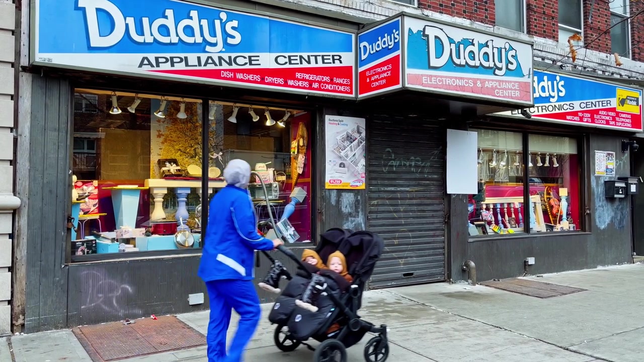 New York, USA, 9 marzo 2022: Uomo chassidico che cammina davanti alla vetrina di elettrodomestici di Duddy. Insegne del negozio "Duddy's Appliance Center" con un uomo chassidico che cammina sul marciapiede, di giorno.