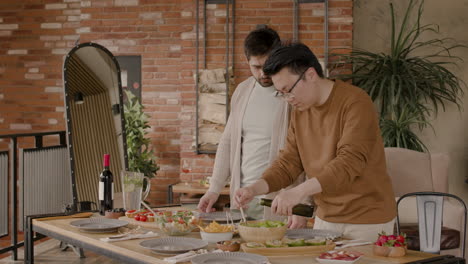 un joven y su amigo preparan una ensalada antes de una reunión de amigos 1