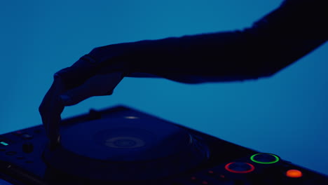 dj mixing on a turntable with a blue background