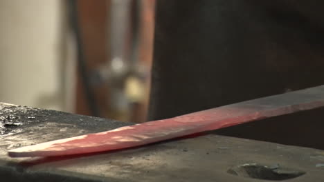 el hombre con el martillo golpea el hierro candente