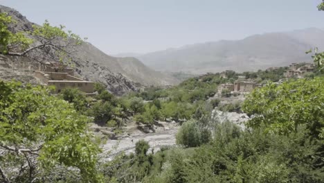 Mix-of-green-foliage-and-deadly-sandy-Panshir-valley,-handheld-view