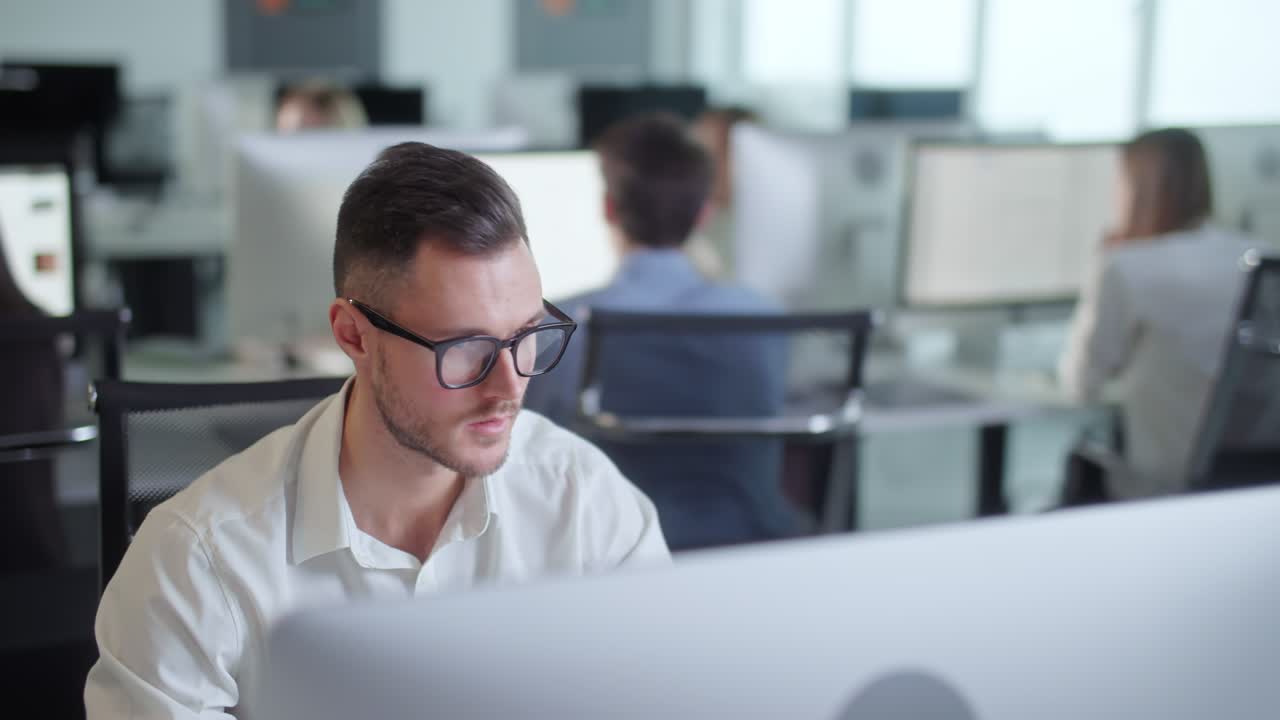 오픈 스페이스 사무실에서 탑 컴퓨터에서 일하는 젊은 기업가의 초상화. pc 키보드에서 타이핑하는 남성 전문가. 컴퓨터 화면을 보는 긍정적 인 사업가 의 초상화