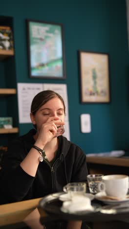 woman drinking water at coffee shop