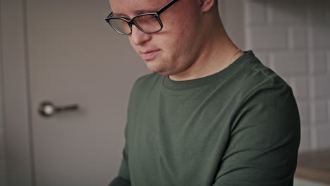 tilt up of adult caucasian man with down syndrome washing dishes at home