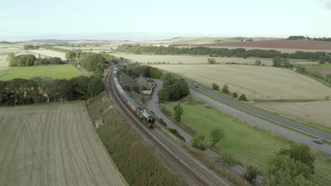 Aerial-view-of-the-Aberdonian-No-60163-Tornado-vintage-steam-train-traveling-through-Aberdeenshire,-Scotland