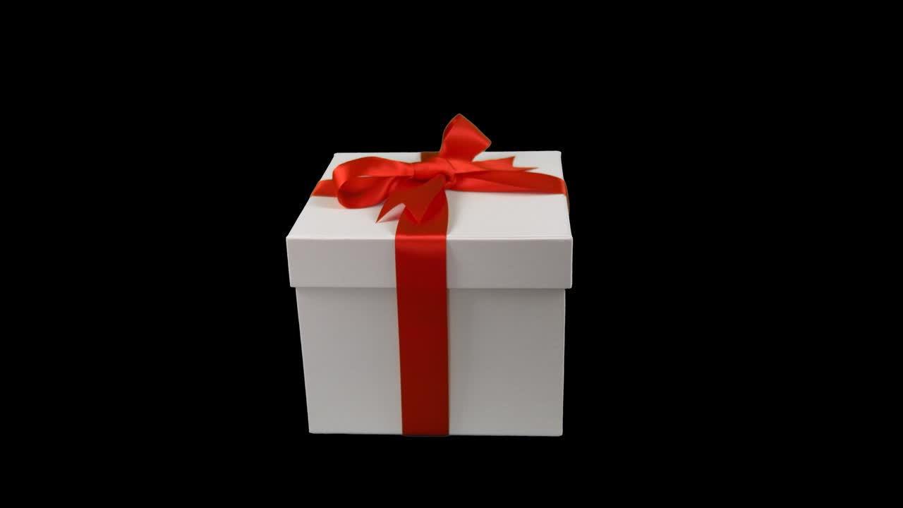 White gift box with red gold ribbon bow dolly in track in zoom in at transparent background. Alpha channel chroma key transparent background. Have empty space for text. Soft focus. LR Pan