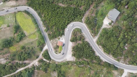 aerial view of cars drive in close line on albanian mountain serpentine road