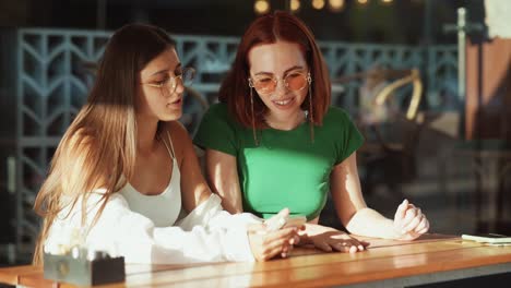 dos amigas chateando en un café