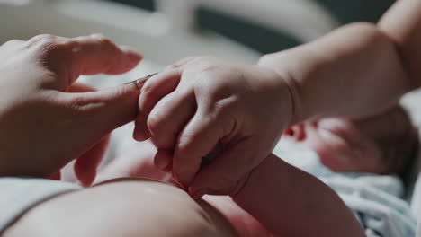 tender moment: newborn baby's hand holds parent's finger