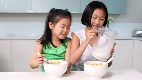 two girls eating cereal