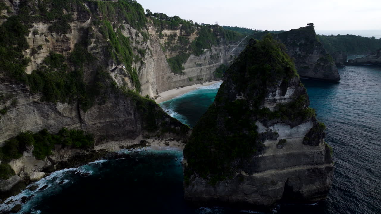 Panoramatický letecký pohled na turistickou pláž Diamond na Nusa Penida při východu slunce.