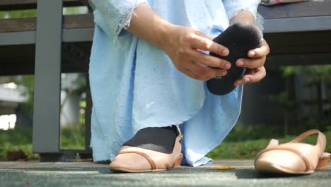 woman putting on socks in the park