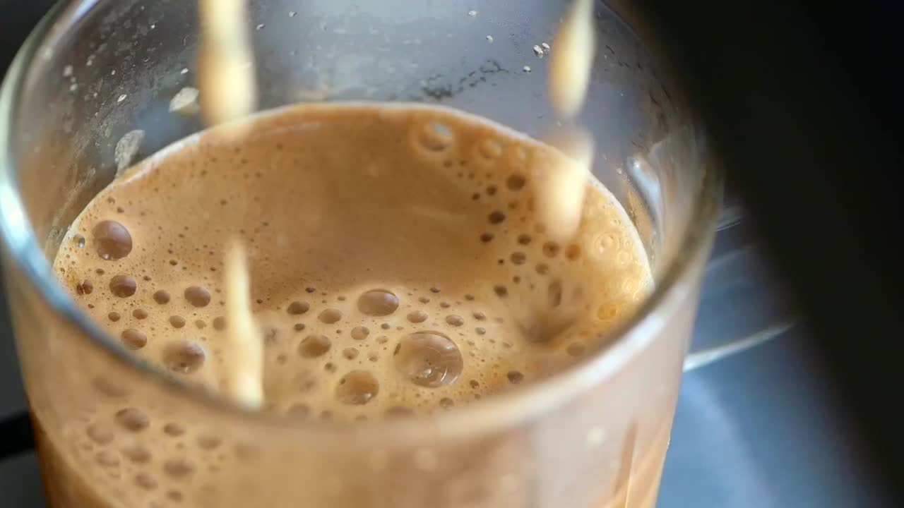 Caffè con schiuma e bolle in un bicchiere