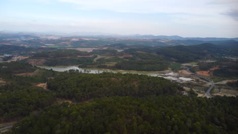 Vista-Aérea-De-Drones-De-Los-Campos-De-Café-De-Ta-Nang-A-Ambos-Lados-De-Un-Gran-Río-En-Vietnam