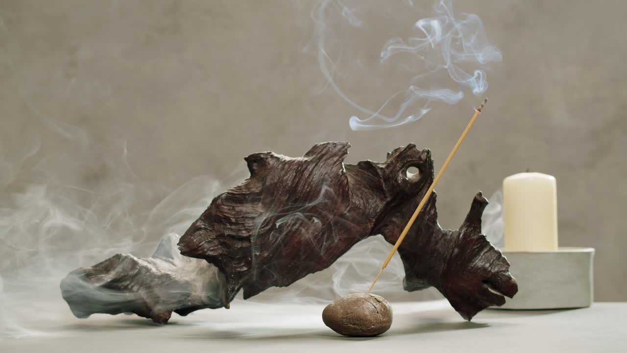 Person holding Palo Santo wood stick in hand, aromatic Palo Santo burning on black background, smoke spreading around, slow motion video clip, high quality 4k close up footage. High quality 4k footage