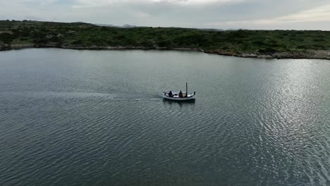 Drone-panning-around-old-wooden-sailing-yacht-in-Menorca,-Spain