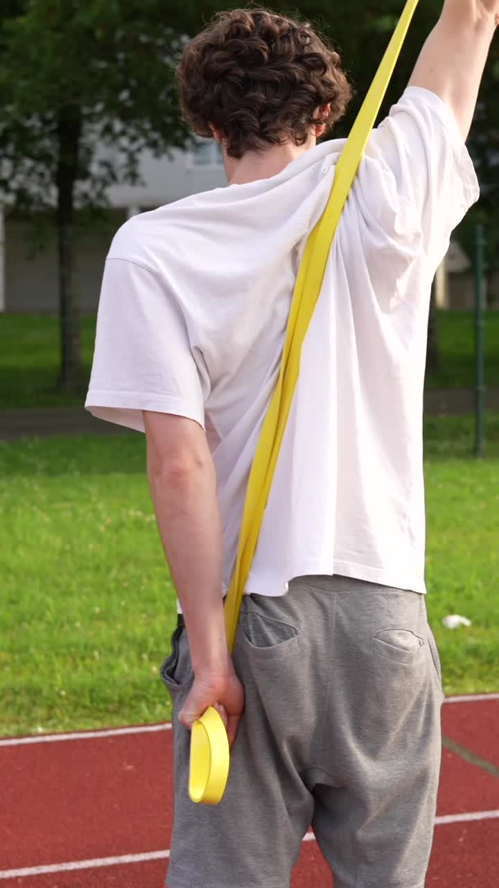 Man exercising with resistance band on track