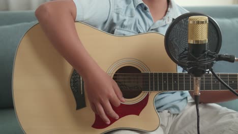 child playing acoustic guitar with microphone