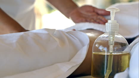 massage therapist using oil during spa therapy