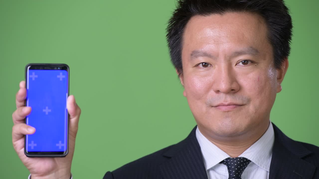 녹색 배경에 성숙한 일본 사업가