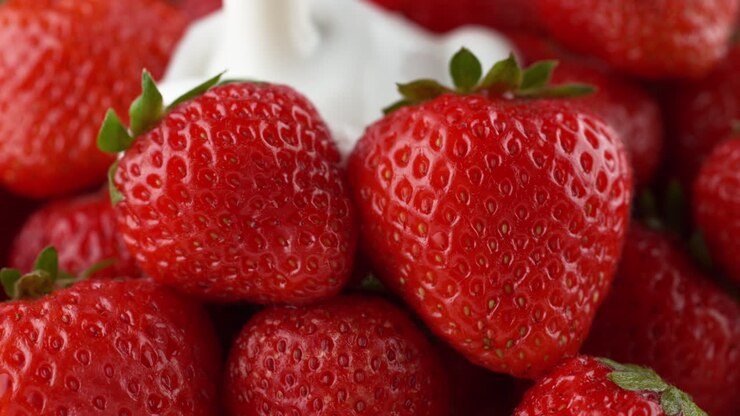 fresas derramadas con yogur - un líquido espeso cubre la fruta en cámara lenta