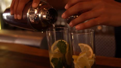 hands of waiter pouring water on a glass