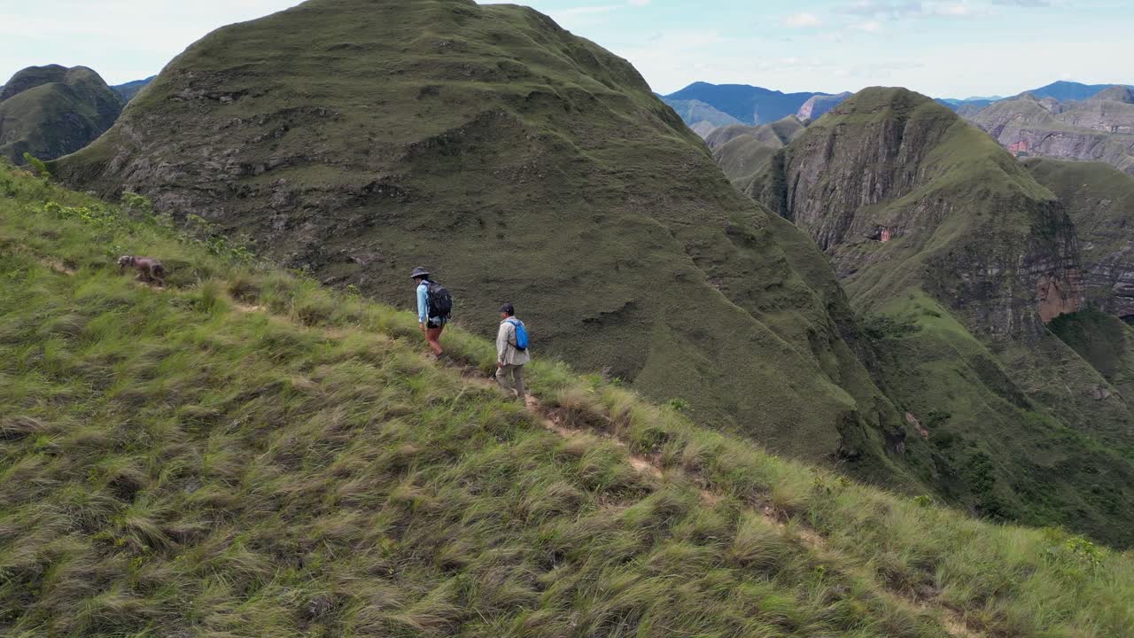 Nature aerial swoops to two hikers on Codo de los Andes mtn ridge path