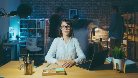 mujer trabajando hasta tarde en la oficina