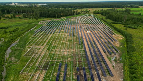 a large solar farm surrounded by greenery on a sunny day, aerial view