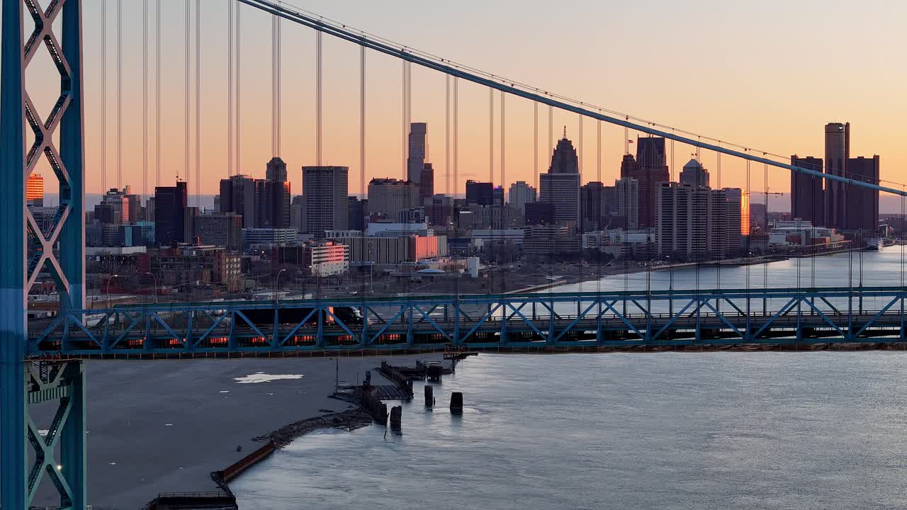 Semi truck passing Ambassador Bridge during sunset, export and import concept, aerial view