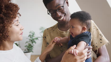 close up of loving parents holding newborn baby son at home in loft apartment