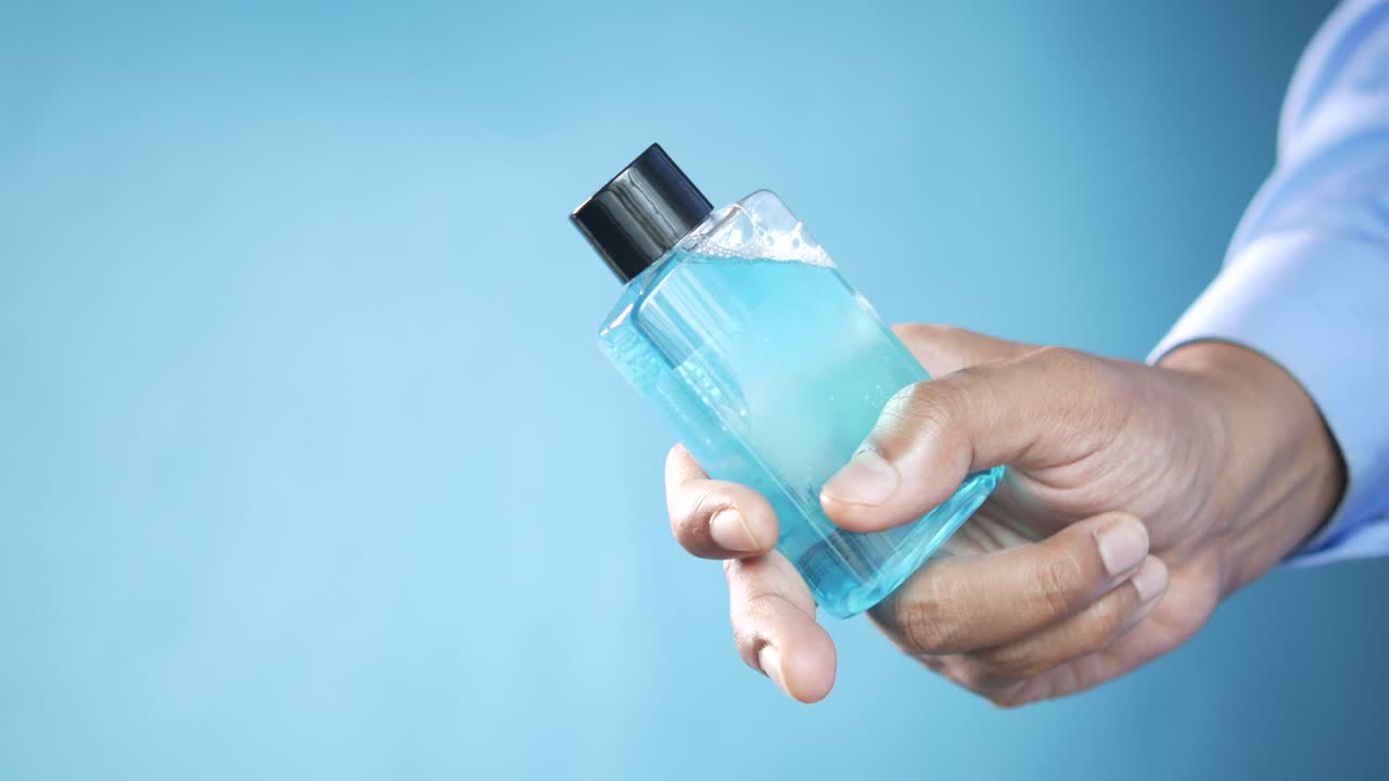 mano con una botella de desinfectante para manos