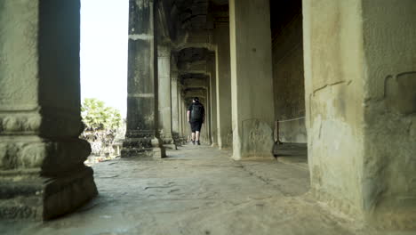 backpacker walking through a historical temple. angkor wat.
