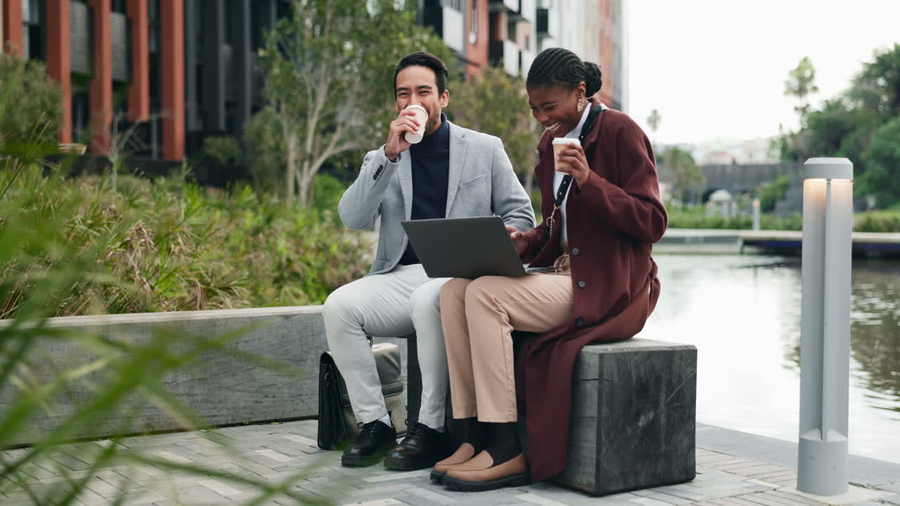 Two Business Professionals Have a Coffee Break and Look at a Laptop