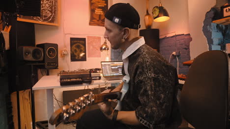 músico tocando la guitarra en un estudio de grabación